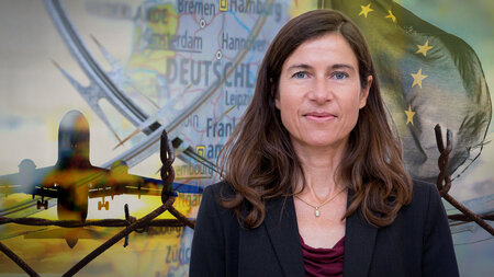 Eine Frau mittleren Alters im Blazer schaut ernst.